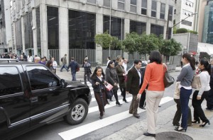 Veículo forçando a passagem em meio à travessia de pedestres