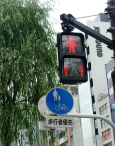 Foco semafórico de pedestres com temporizador e regulamentação do compartilhamento da calçada entre os pedestres e ciclistas