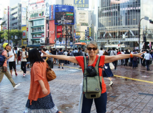 Feliz da vida no meio da lotada travessia de pedestres em “X” ao lado da Estação Shibuya, Tókyo.