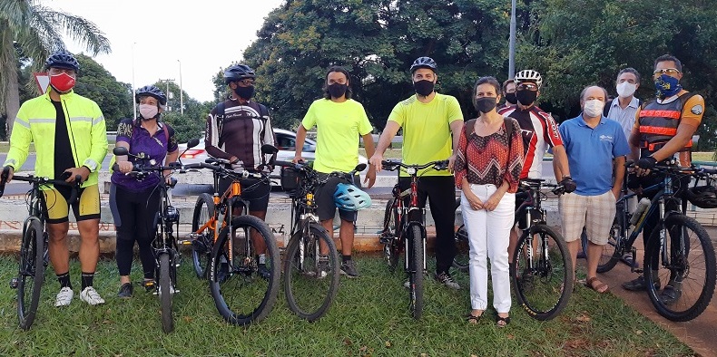 Grupo de pessoas posando para foto com bicicleta

Descrição gerada automaticamente