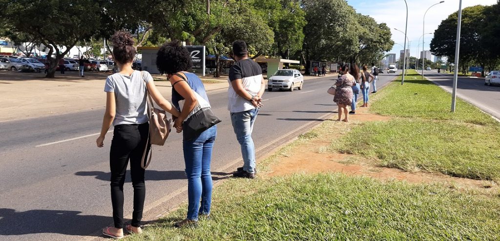 Pessoas andando na calçada com grama

Descrição gerada automaticamente