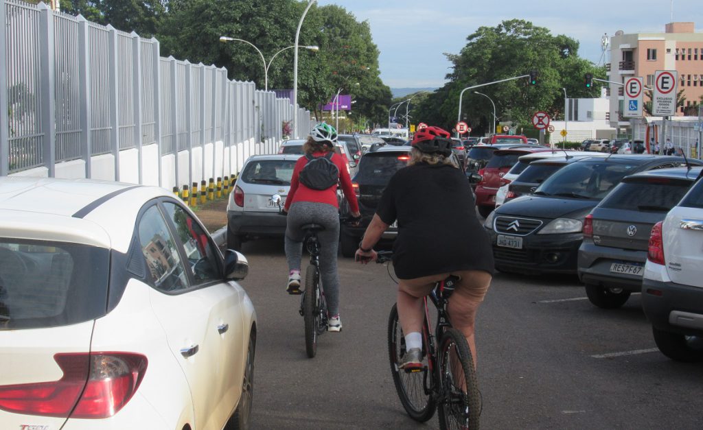 Homem andando de bicicleta ao lado de carro

Descrição gerada automaticamente