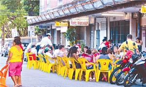 Calçada ocupada pelas mesas e cadeiras de um bar