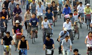 Chineses andam de bicicleta em avenida de Pequim