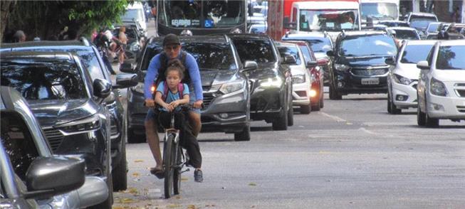 Ciclista espremido entre os carros. Falta ciclovia