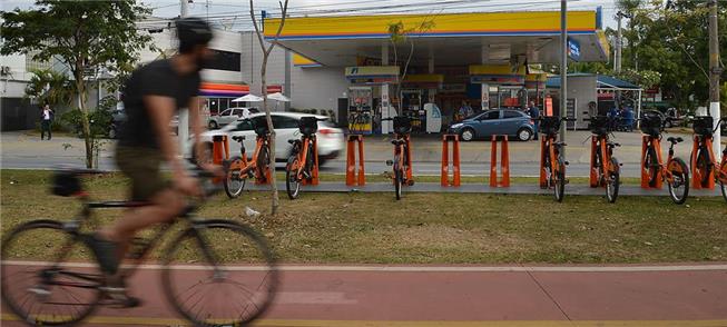 Ciclista observa bikes públicas em avenida de São