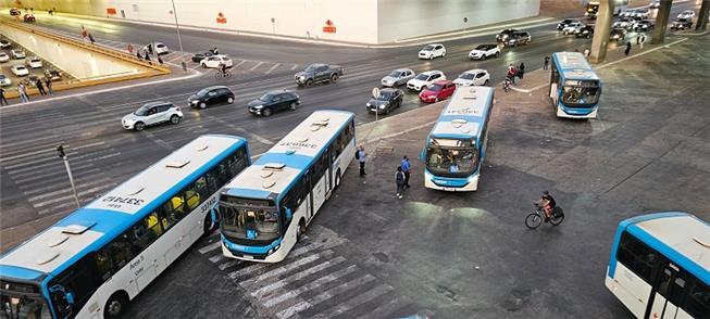 Ciclista sem segurança em meio a ônibus, na Rodovi