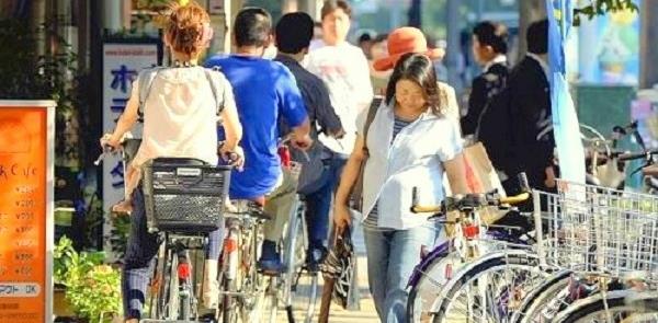 Ciclistas na calçada, em Tóquio, Japão