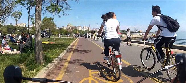 Ciclistas passeiam pela orla de praia perto de Ist