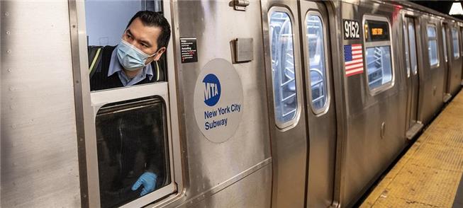 Fiscal da MTA observa plataforma em trem do metrô