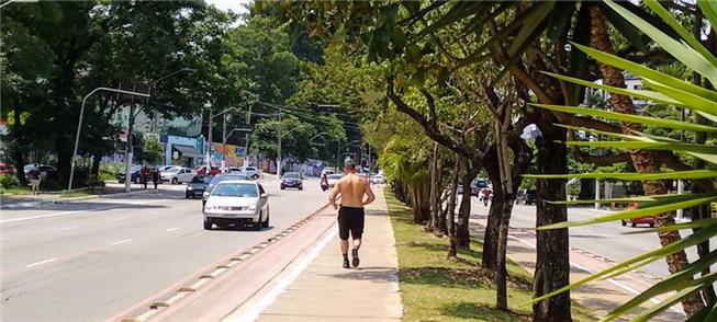 Homem corre por via plana e arborizada, algo raro