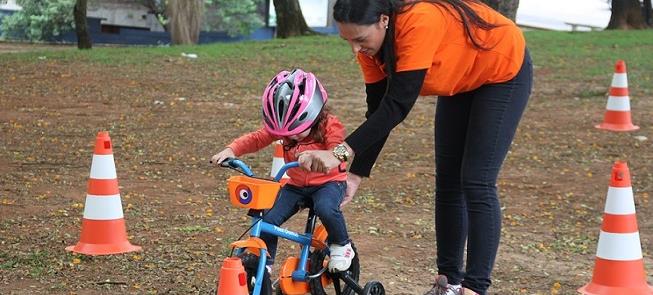 Monitores ensinam crianças pequenas a pedalar