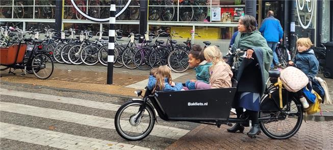Mulher transporta cinco crianças em uma bicicleta