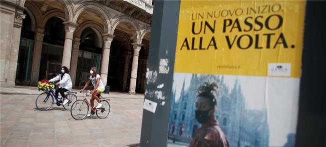 Mulheres pedalam em Milão ao final da quarentena o