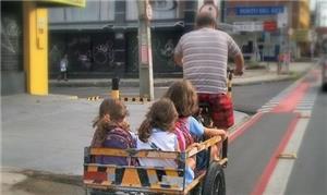 Pai transporta filhas à escola em ciclovia de Fort