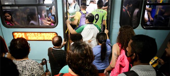 Passageiros tentam embarcar em ônibus no terminal