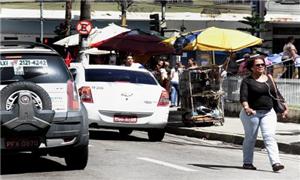 Pedestre caminha com fone no ouvido pelas ruas do