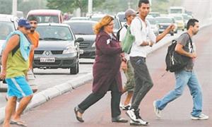 Pedestres atravessam na pista de ônibus