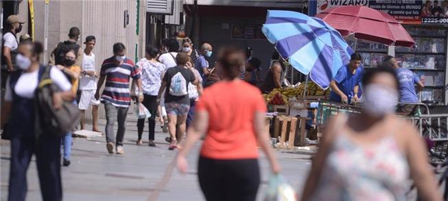 Pedestres caminham com máscaras no Rio de Janeiro