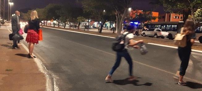 Pedestres correm para atravessar via em Brasília
