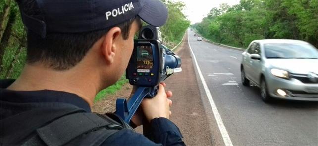 Policial federal utilizando radar móvel em estrada