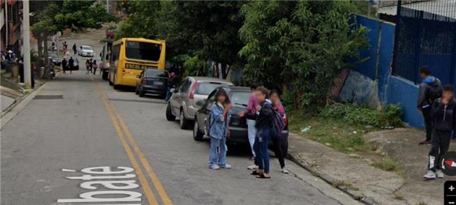 Sem calçadas adequadas, estudantes caminham pela r