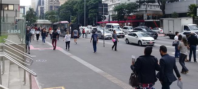 Trabalhadores caminham pela Avenida Paulista, em S