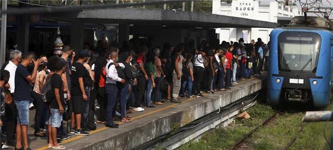 Trem chega à estação Bangu, com a plataforma lotad